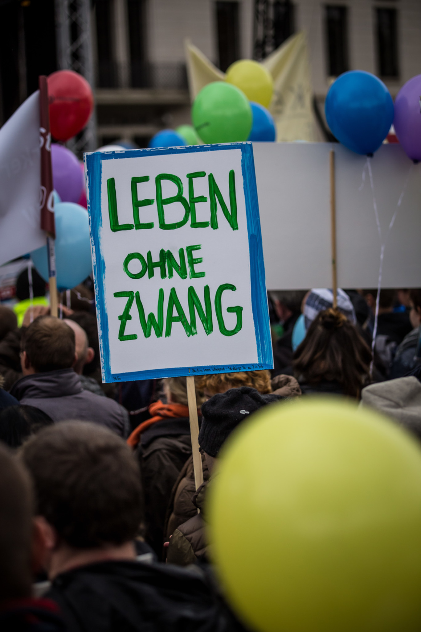 Protestierende Menschen; Schild "Leben ohne Zwang"